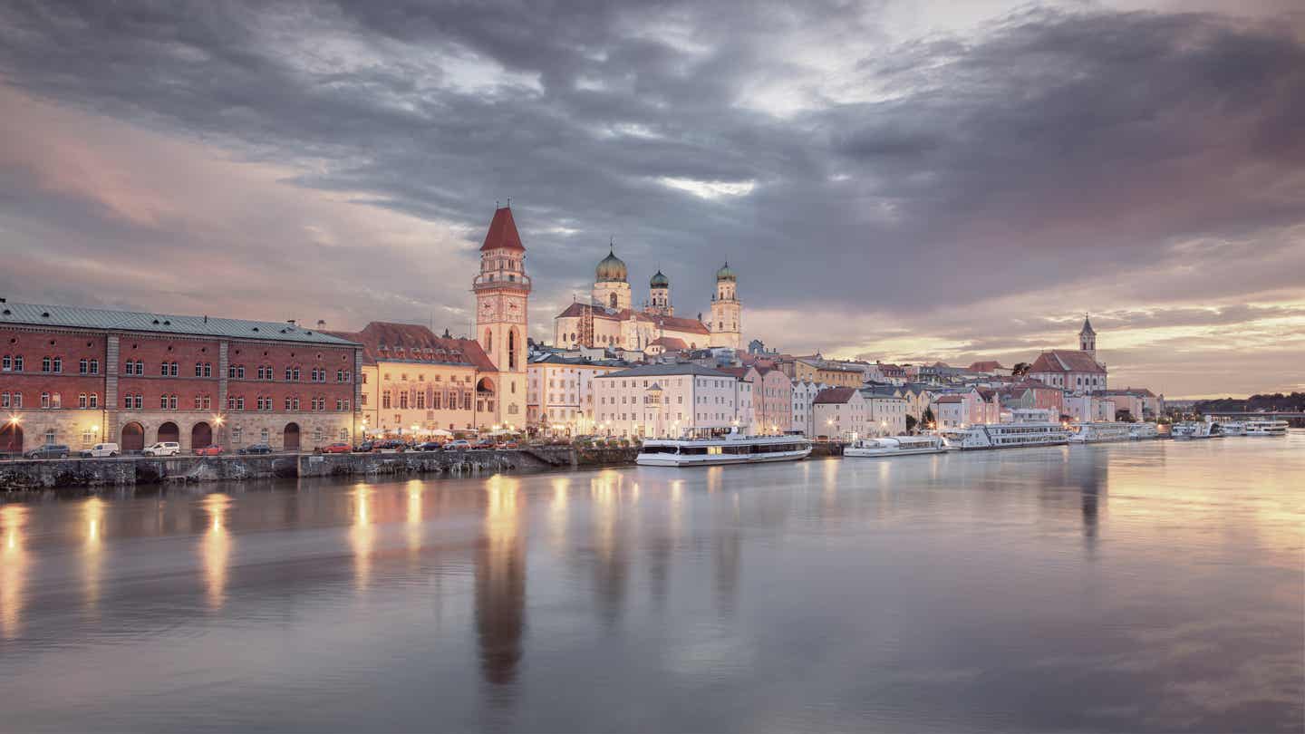 Bayerischer Wald Urlaub mit DERTOUR. Blick über die Donau auf Passau bei Sonnenuntergang