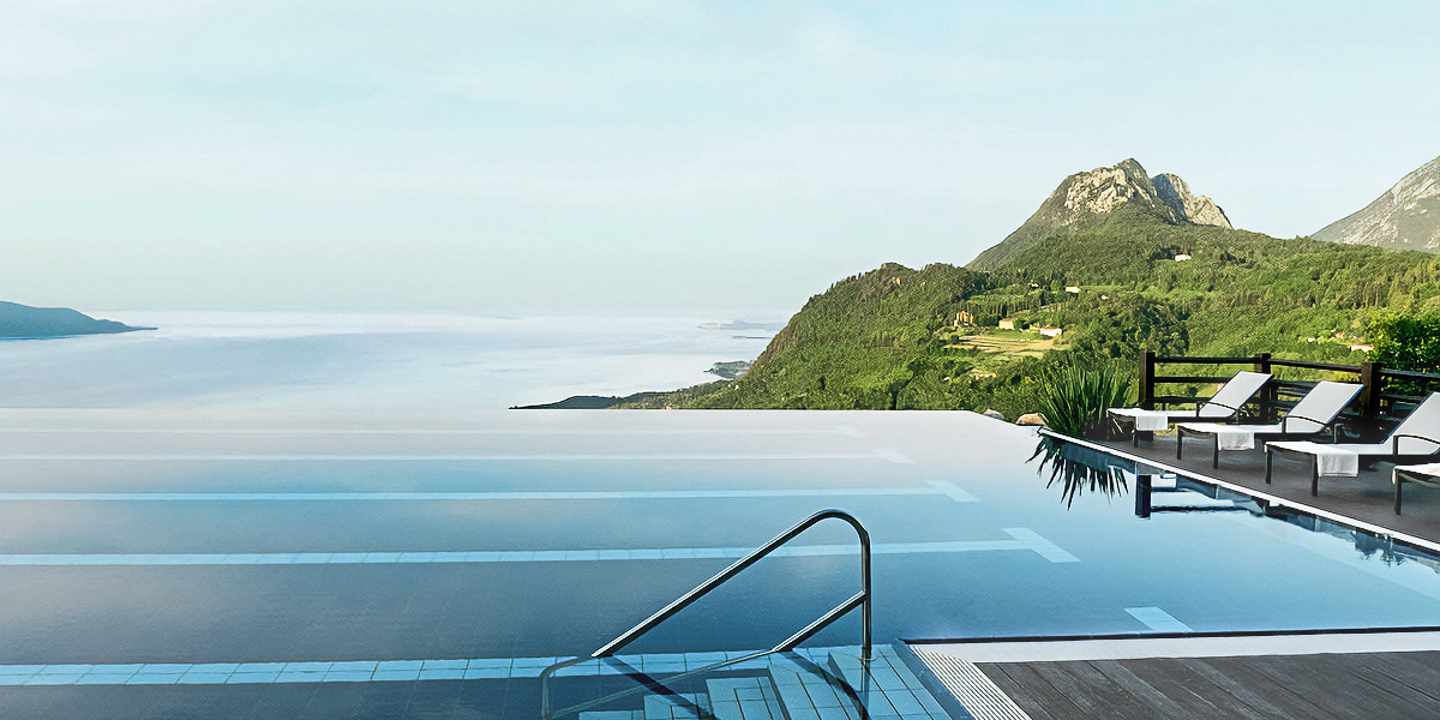 Infinitypool mit Blick auf grüne Bergkulisse und See beim Wellnessurlaub in Italien