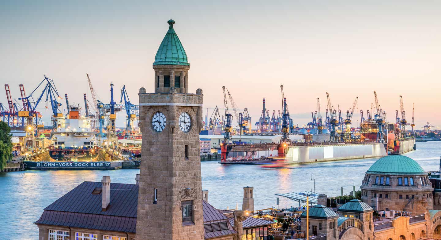 Blick über den Hamburger Hafen mit dem Uhrturm in Vordergrund und den Kränen auf den anderen Seite der Elbe im Hintergrund