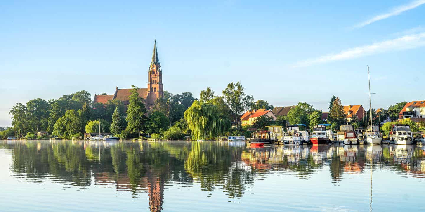 Blick auf den Ort Röbel an der Müritz, links die markante Kirche, rechts an paar kleine Boote am Anleger