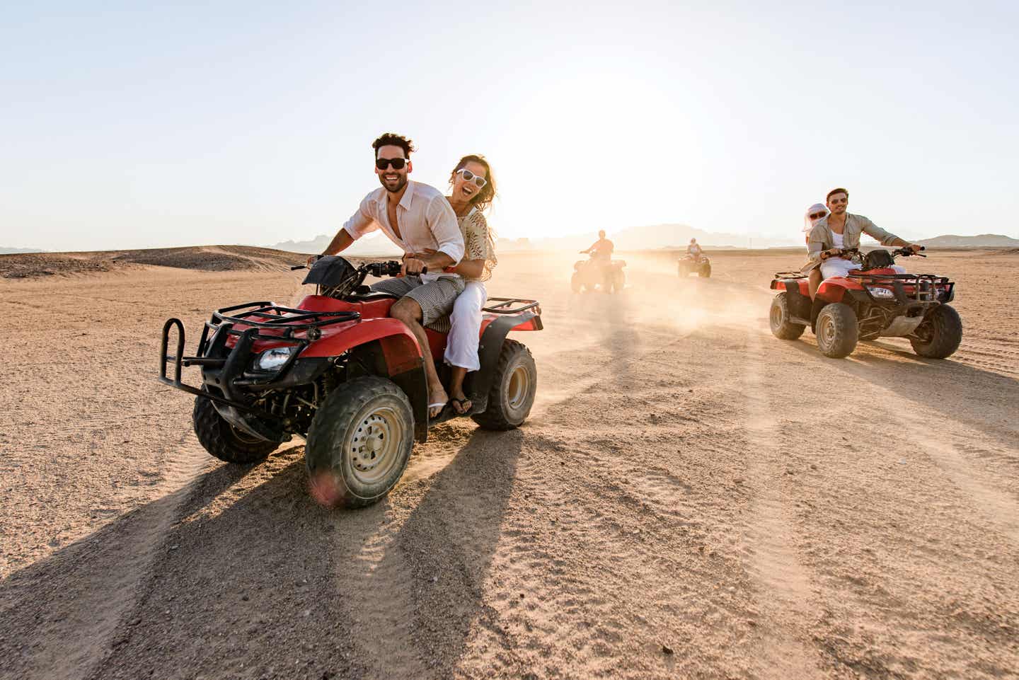 Glückliche Freunde fahren bei Sonnenuntergang auf Quads durch die Wüste in Ägypten Quad-Tour bei Sonnenuntergang in der Wüste Ägyptens
