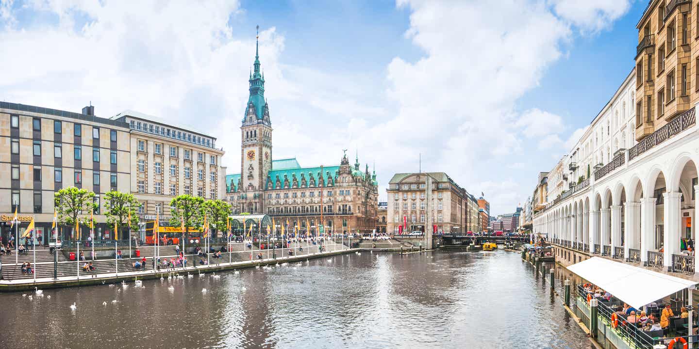 Blick auf das Hamburger Rathaus und die Kleine Alster mit Ausflugsschiff und Straßencafé im Vordergrund