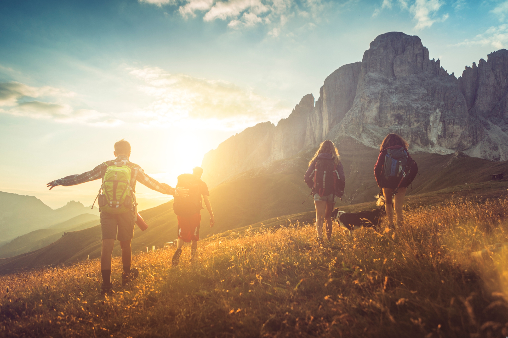 Reisekalender September. Wanderer in Südtirol. Sonne strahlt über einem Berg