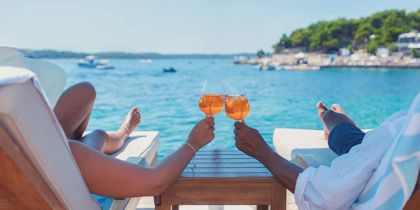 Kroatien Urlaub - Mann und Frau genießen einen Drink und blicken aufs Meer