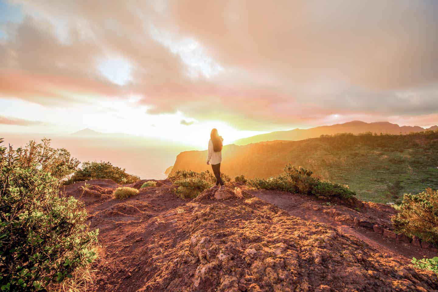 La Gomera Urlaub mit DERTOUR. Frau vor Sonnenaufgang am Aussichtspunkt Mirador de Abrante