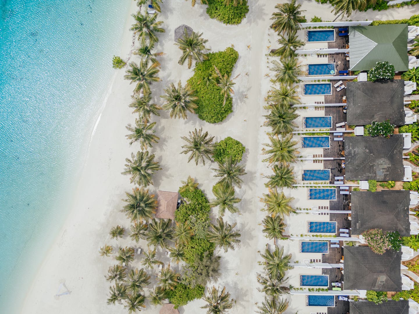 Topshot einer Drohne auf Strandvillen mit eigenem Pool