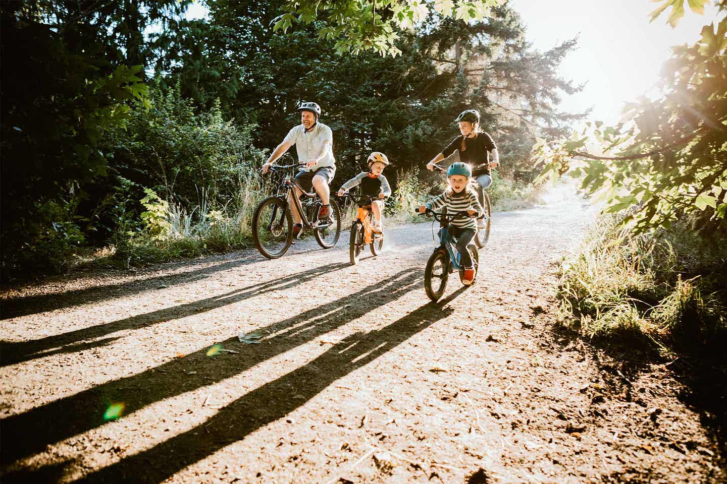 Ein Familienausflug mit Fahrrädern führt durch einen Wald beim Urlaub in Bayern