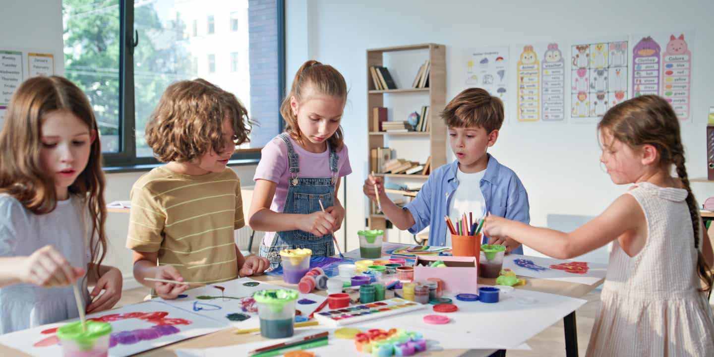 Schlechtwetter-Ausflug mit Kindern: 5 Kinder malen gemeinsam in einer Kreativwerkstatt 