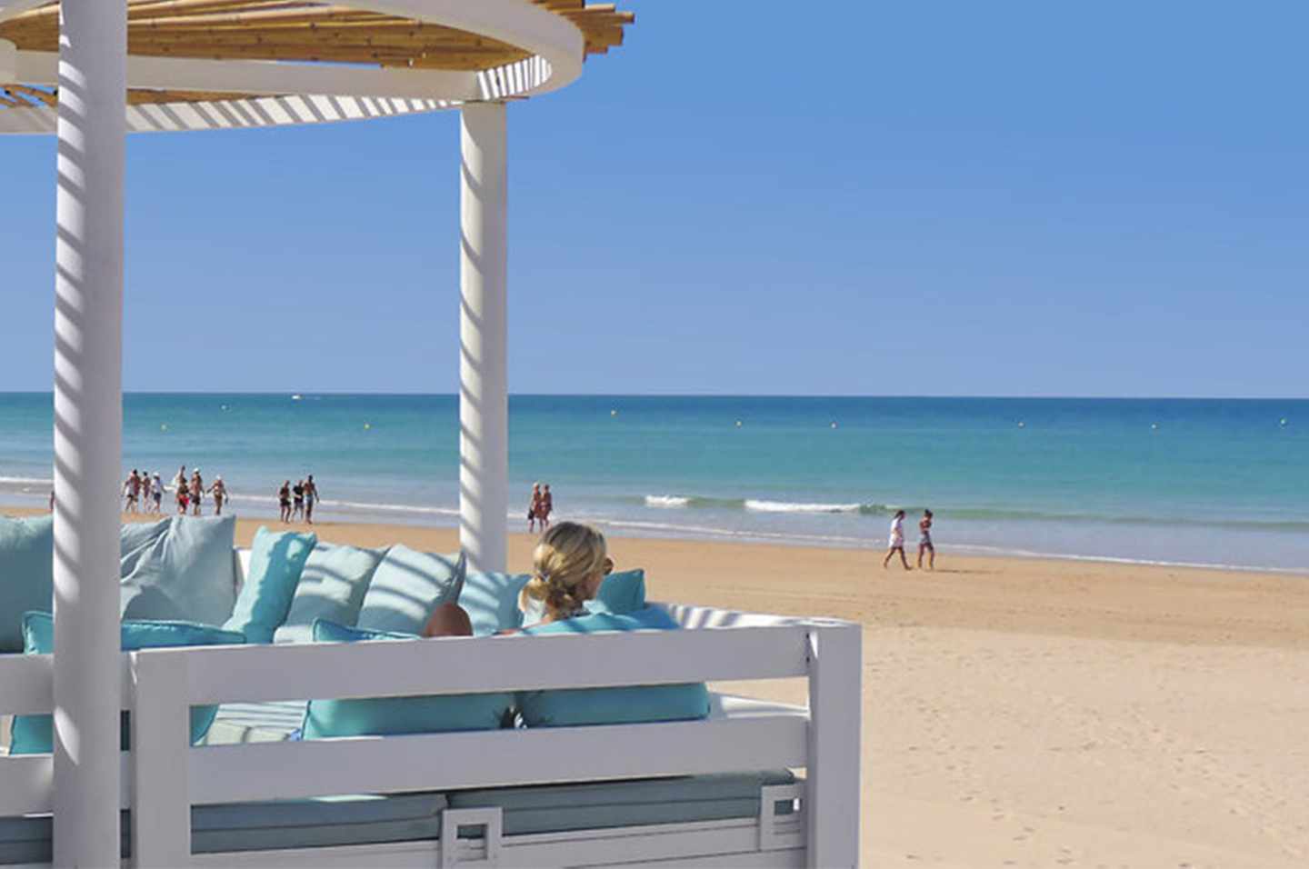 Frau sitzt in einer Strandbar am andalusischen Strand