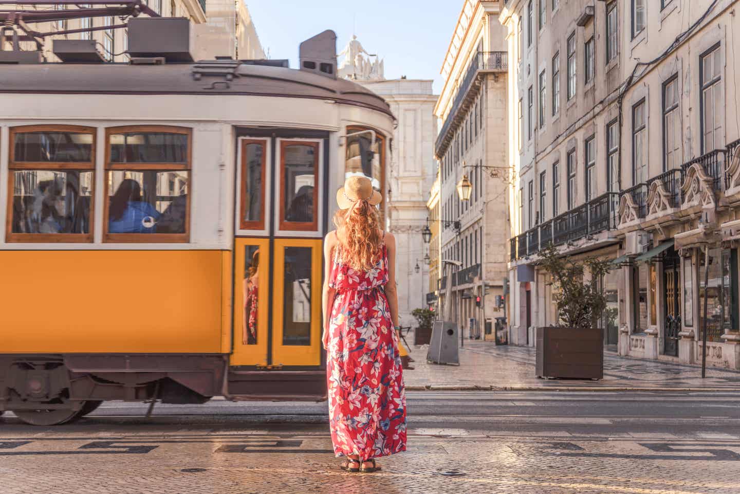 Frau mit Sommerkleid vor der gelben Tram 28 in Lissabon – Szene im Stil der Main Character Energy