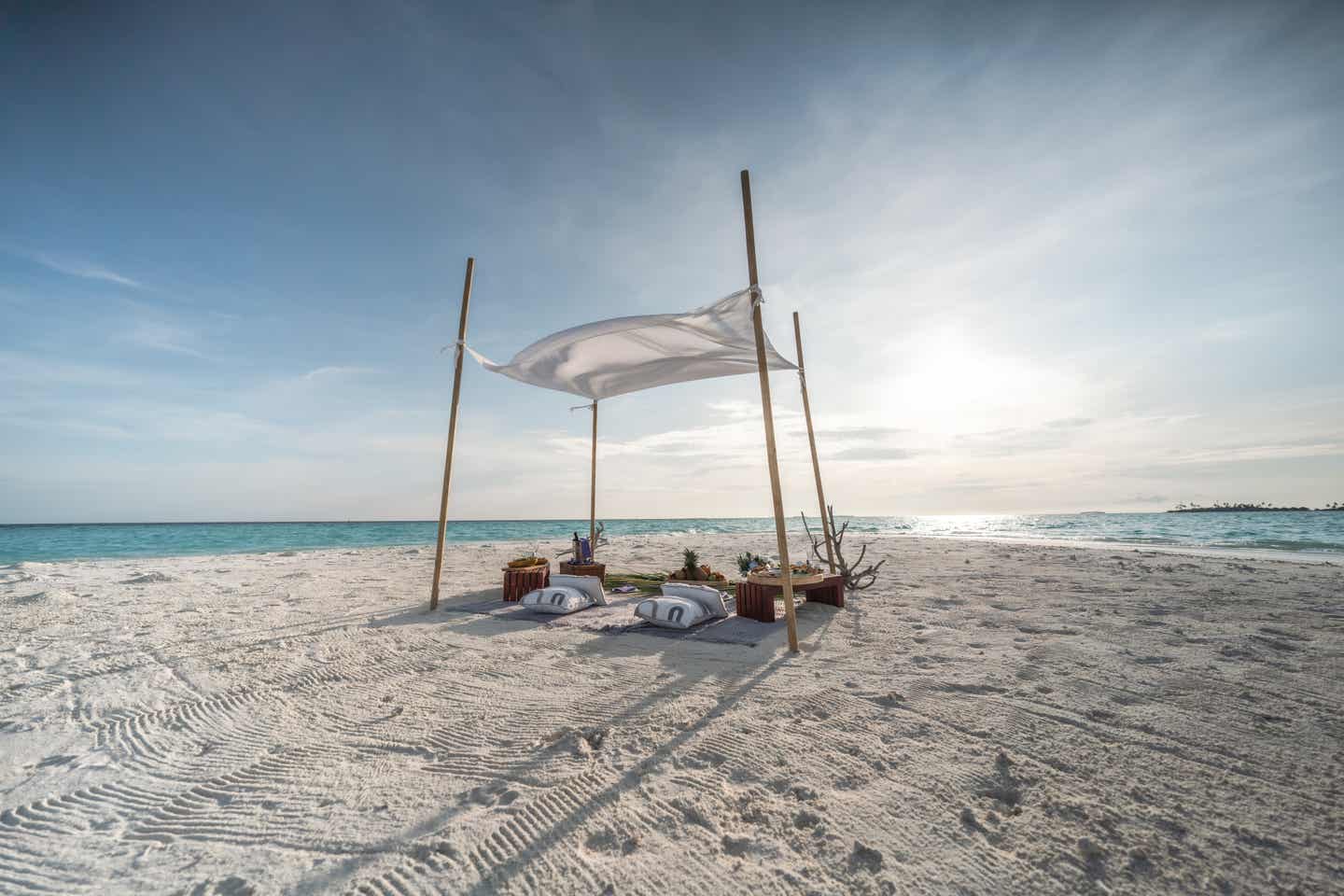 Ein romantisches Dinner unter einem Paravant am menschenleeren Strand auf den Malediven