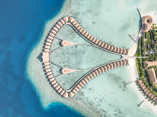 Topshot einer Drohne auf das Hotel und die Wasservillen im Ozean