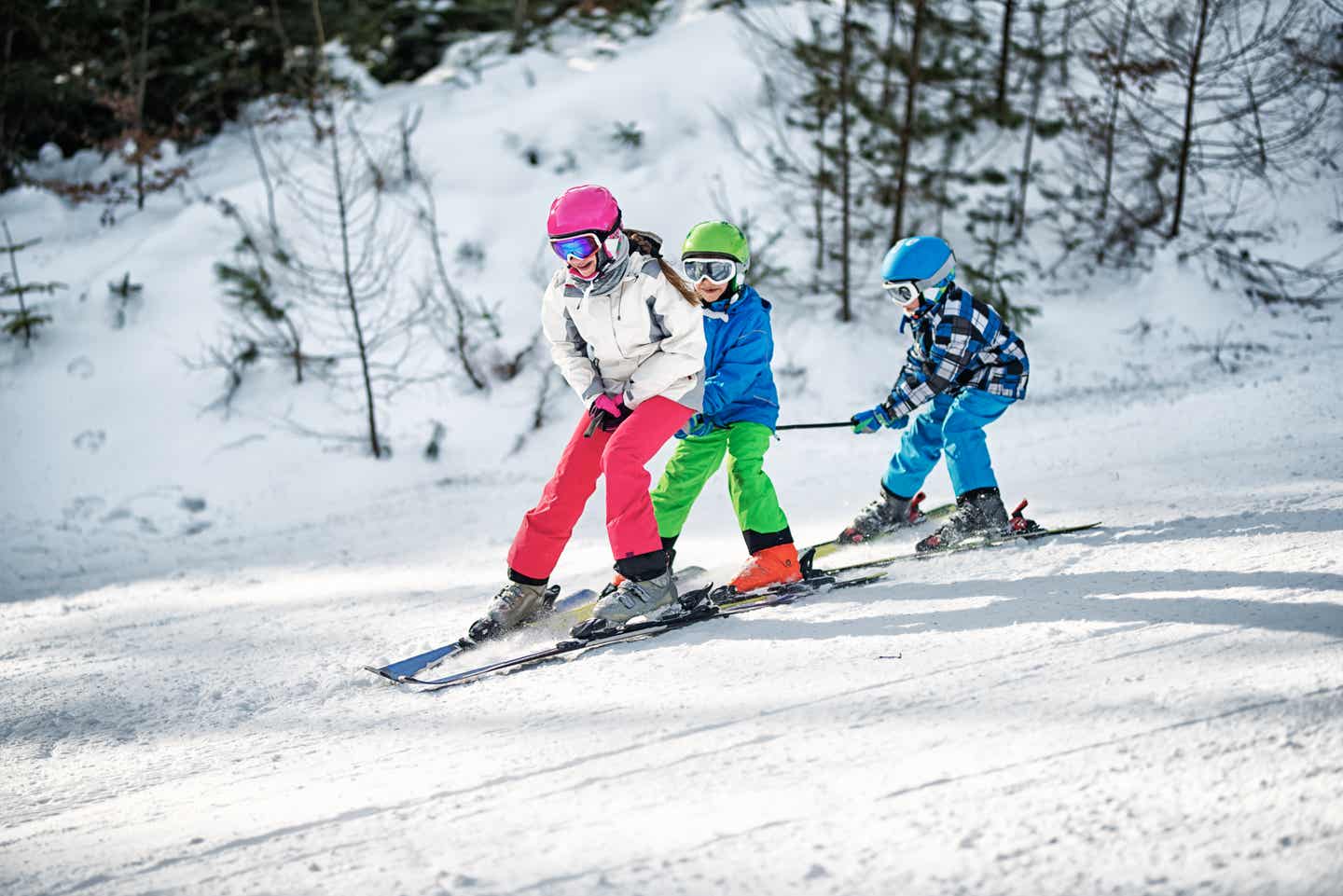 Drei Kinder fahren gemeinsam Ski