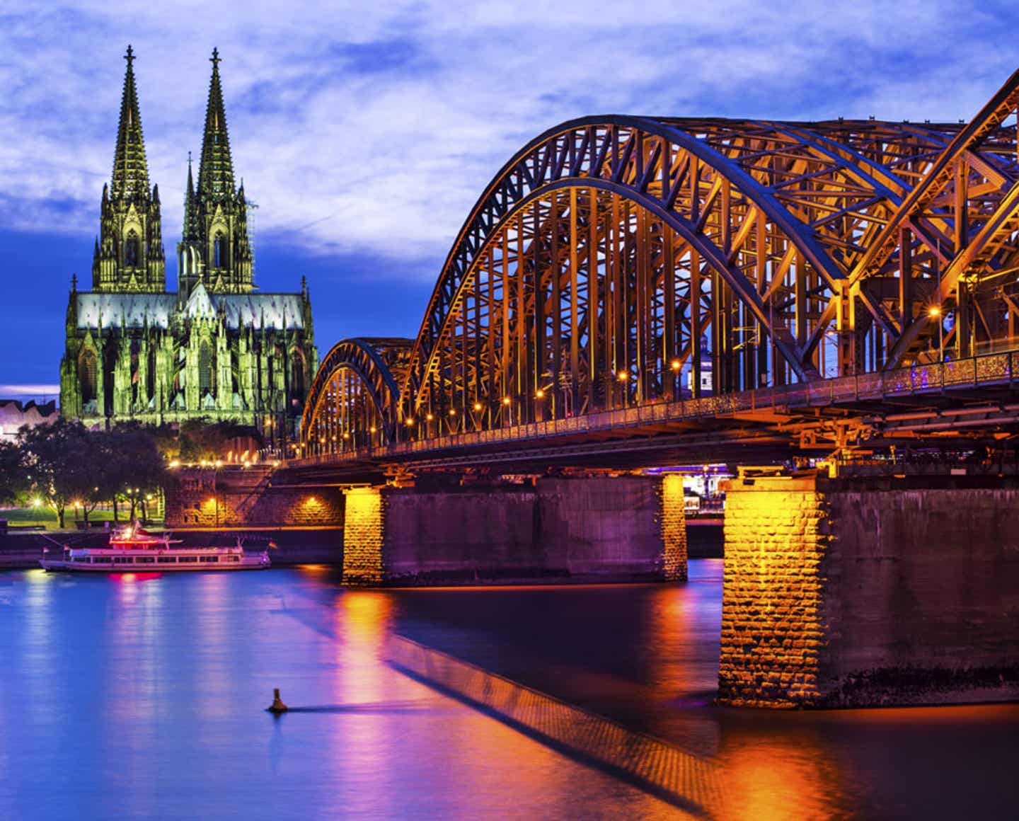 FC Köln Tickets und Hotel. Kölner Dom und Hohenzollernbrücke in der Abenddämmerung.