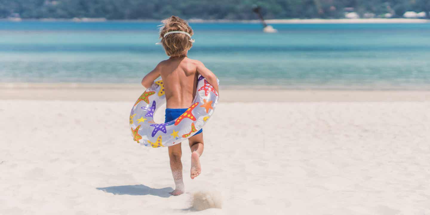 Mallorca Urlaub: Ein kleiner Junge spielt am Sandstrand.