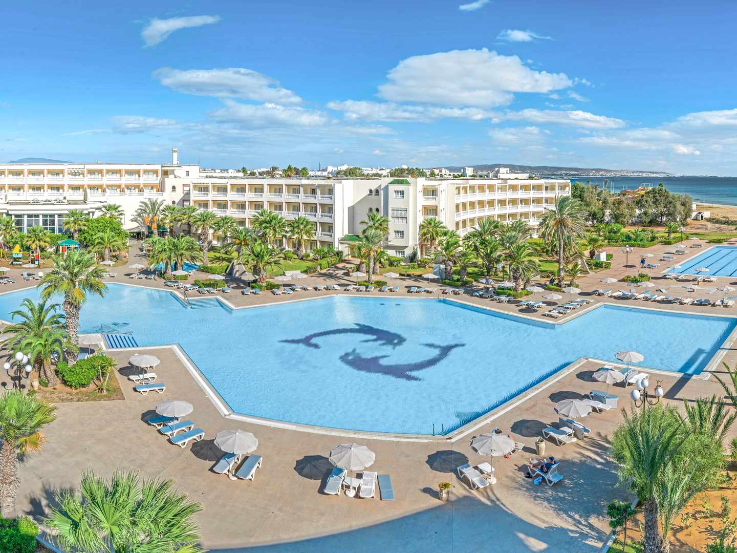 Drohnenblick auf Pool und Strand vom Sentido