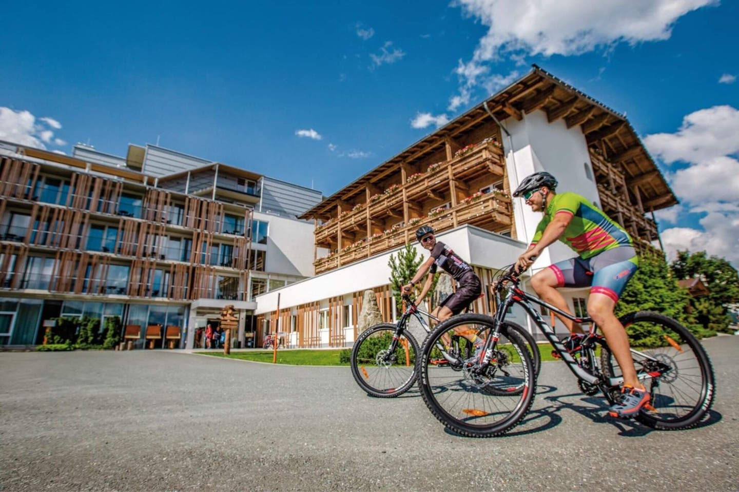 Paar auf Mountainbikes vor dem Sentido alpenhotel Kaiserfels