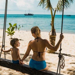 thailand-familienurlaub-rueckansicht-des-mutter-und-sohn-hand-in-hand-beim-schwingen-am-strand-g-1069482872.jpg