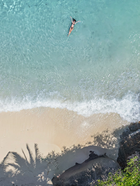 Sommerurlaub: Luftaufnahme einer Frau im Wasser auf den Seychellen