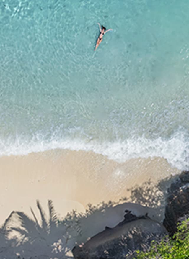 Mehr Infos hier Sommerurlaub: Luftaufnahme einer Frau im Wasser auf den Seychellen