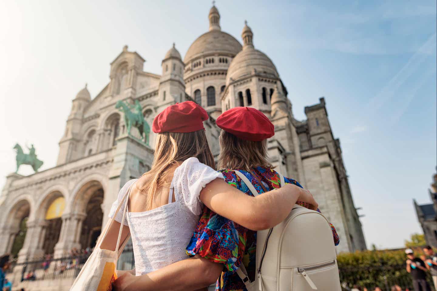Mutter und Tochter mit roten Baksenmützen von hinten vor Sacre Coeur
