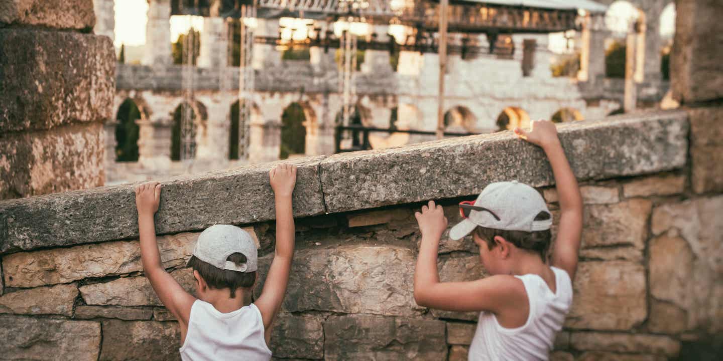 Familienurlaub in Kroatien: zwei Jungs klettern an einer Mauer in Pula