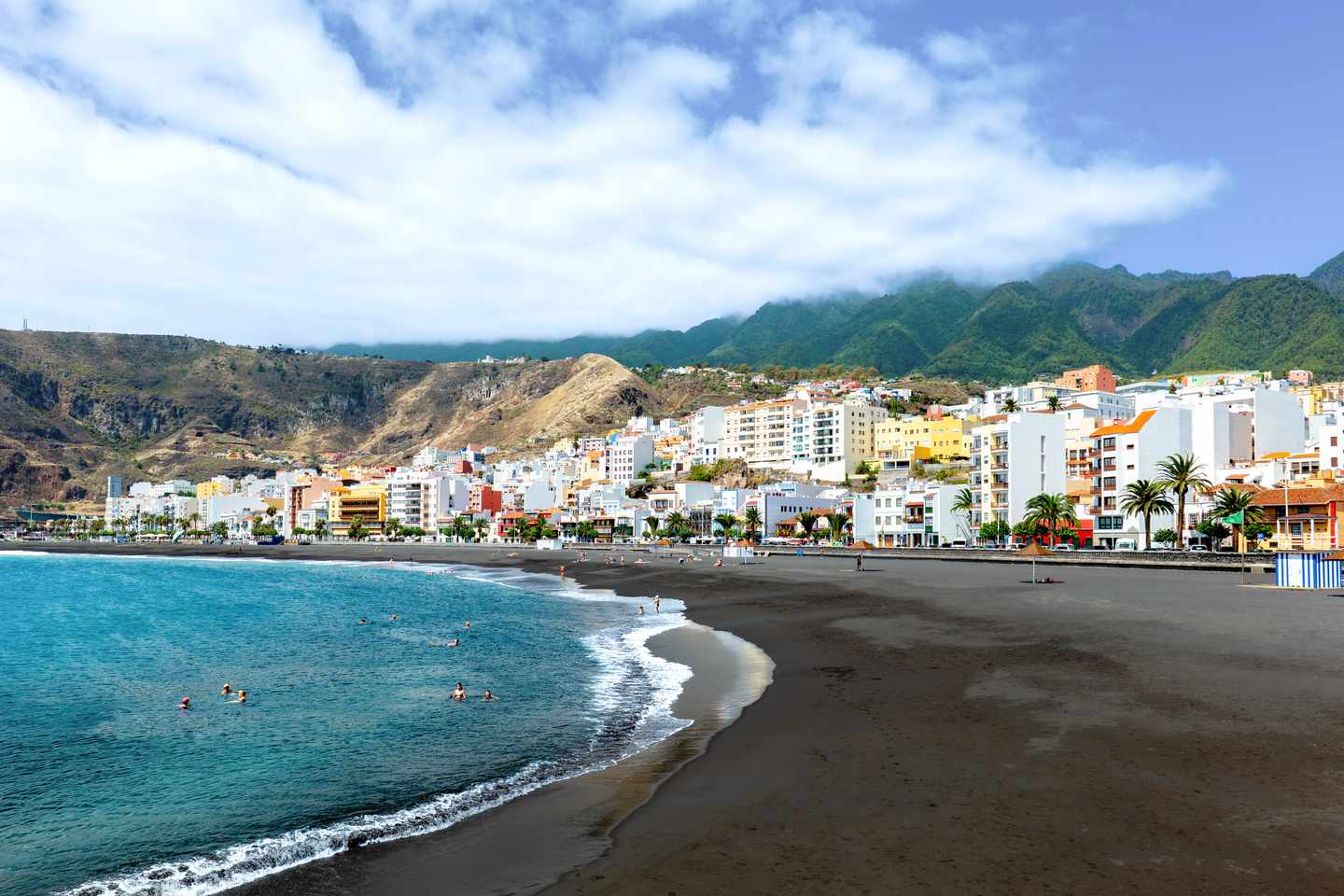 Schwarzer Sandstrand von Santa Cruz de La Palma mit historischer Uferpromenade und Blick auf die grüne Bergkulisse
