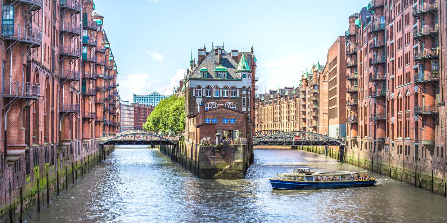 Blick auf das historische Wasserschloss in der Speicherstadt Hamburg mit der Elbphilharmonie im Hintergrund