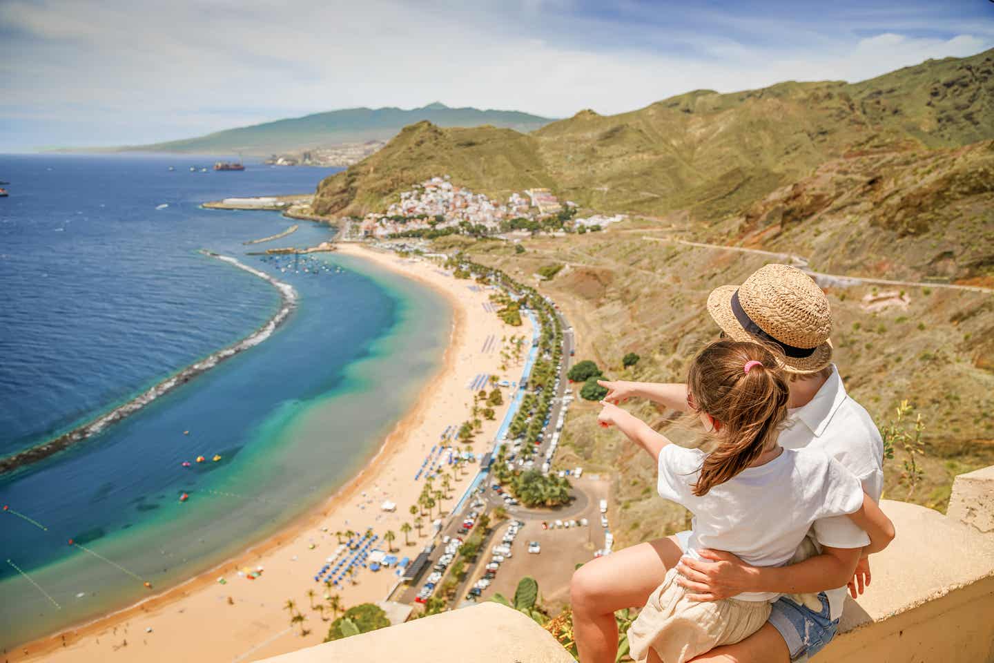 Mutter mit Kind blickt auf den Strand Las Teresitas bei Santa Cruz de Tenerife mit hellgoldenem Sand und ruhigem Meer