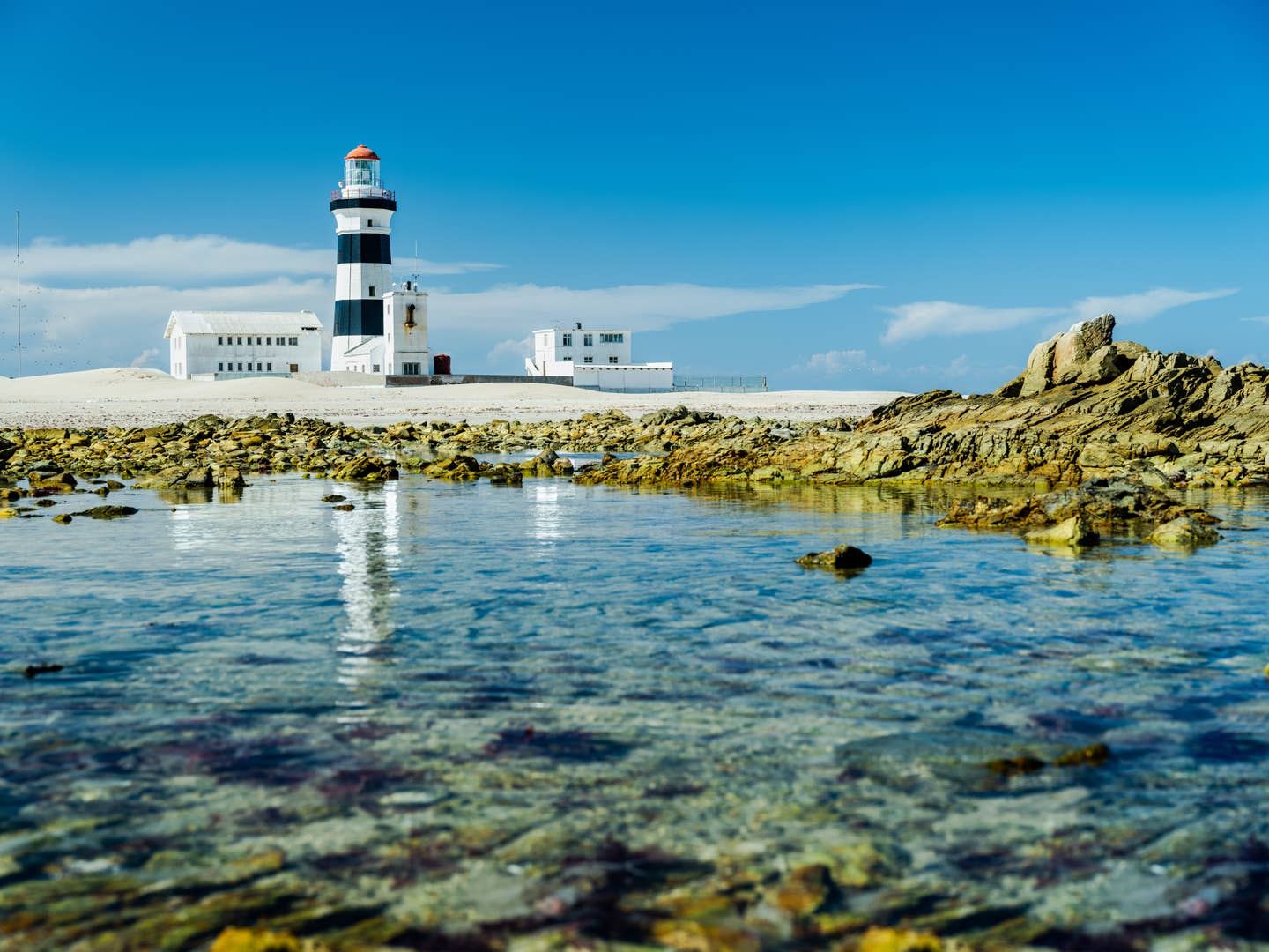 Rundreisen Port Elizabeth: Leuchtturm am Cape Recife mit klarem Meer im Vordergrund Rundreisen Port Elizabeth: Leuchtturm am Cape Recife mit klarem Meer im Vordergrund