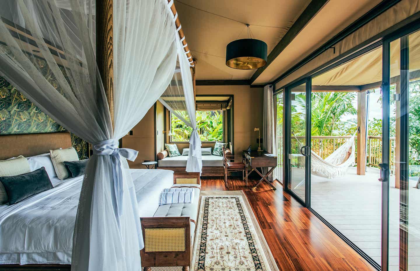 Ein luxuriöses Hotelzimmer auf Costa Rica, links ein großes Bett, rechts der Balkon mit Hängematte