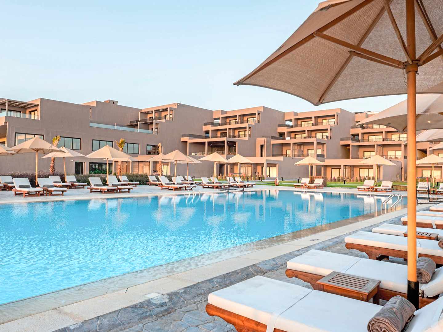 Großzügige Poollandschaft im Sentido Naga Bay in Ägypten mit Sonnenliegen, Sonnenschirmen und Resortgebäuden im Hintergrund