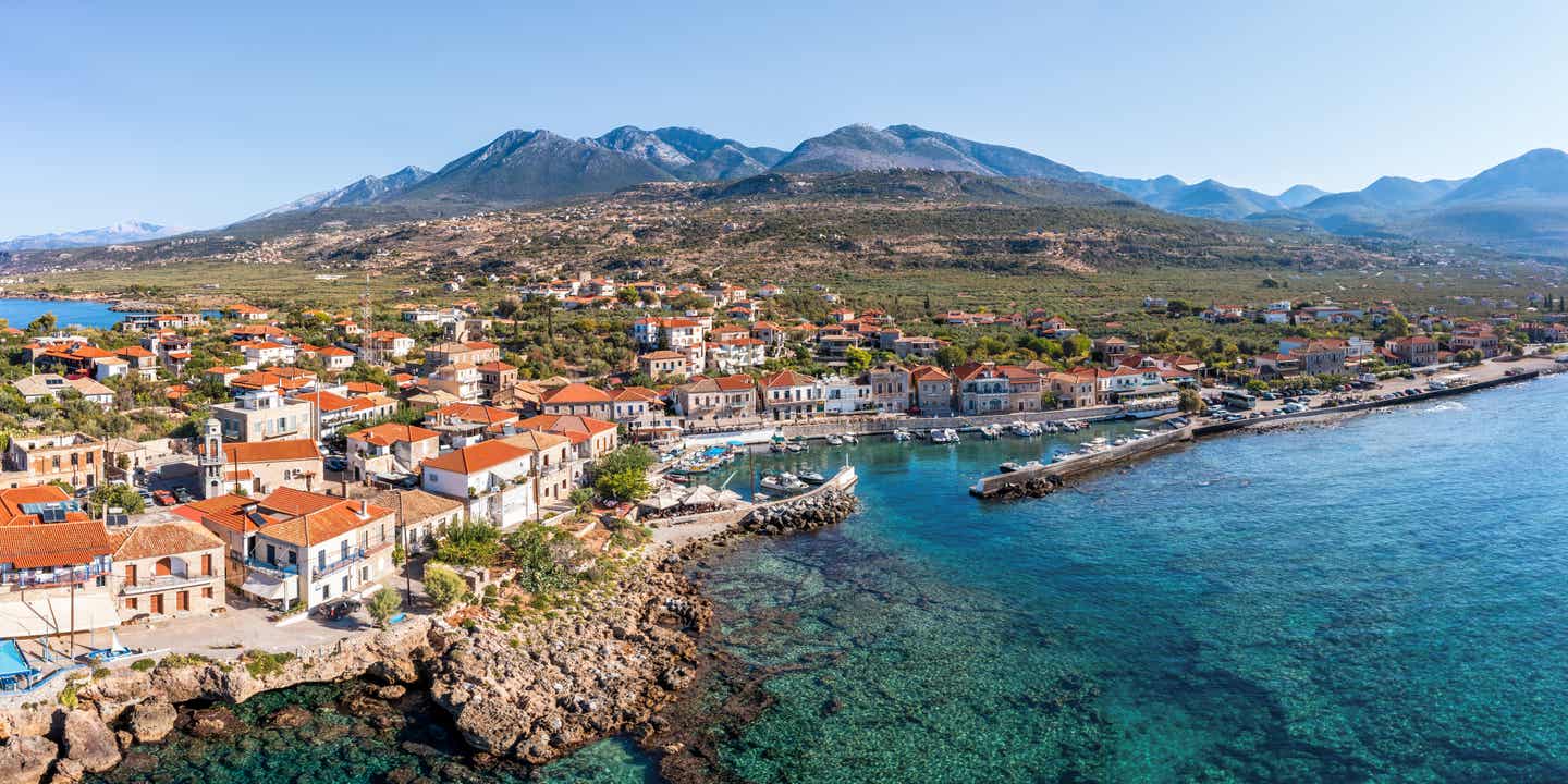 Vogelperspektive auf eine Küstenstadt mit Kiesstrand und klarem Wasser