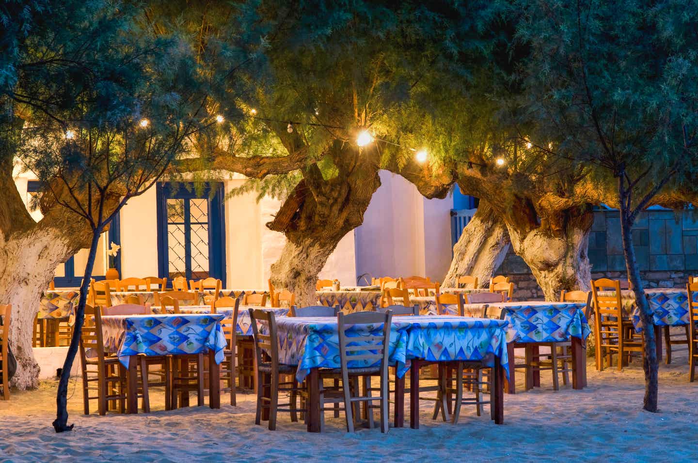 Blick auf eine abendlich beleuchtete Taverne im typisch griechischen Stil