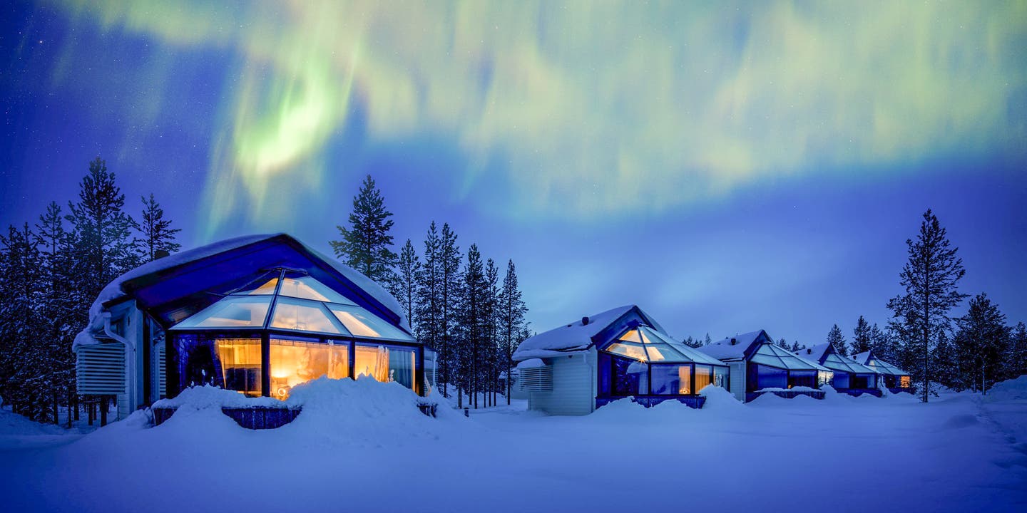 Glas-Iglu-Hotel unter Polarlichtern in der Nacht im Schnee