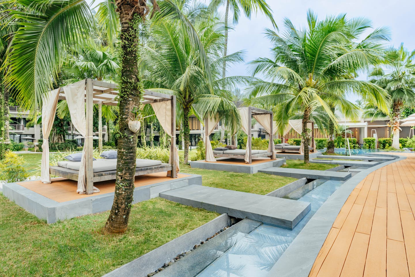 Cabanas unter Palmen am Hotelpool