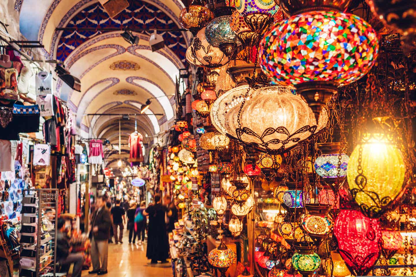 Blick auf einen überdachten türkischen Basar mit bunten Lampenschirmen und Marktbesuchern