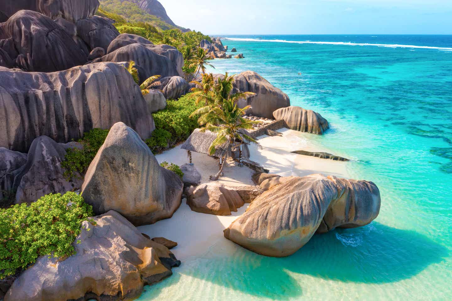 Eine offene Holzhütte zwischen den Grantifelsen auf den Seychellen am Strand