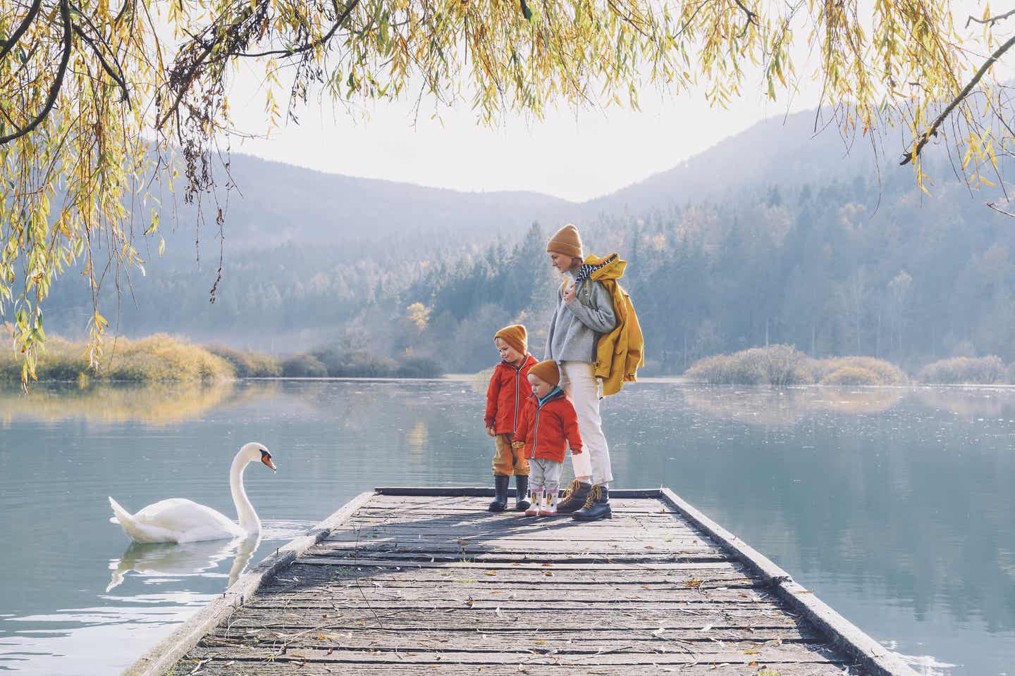 Nachhaltige Erlebnisse mit Kindern: Familie auf einem Steg am See