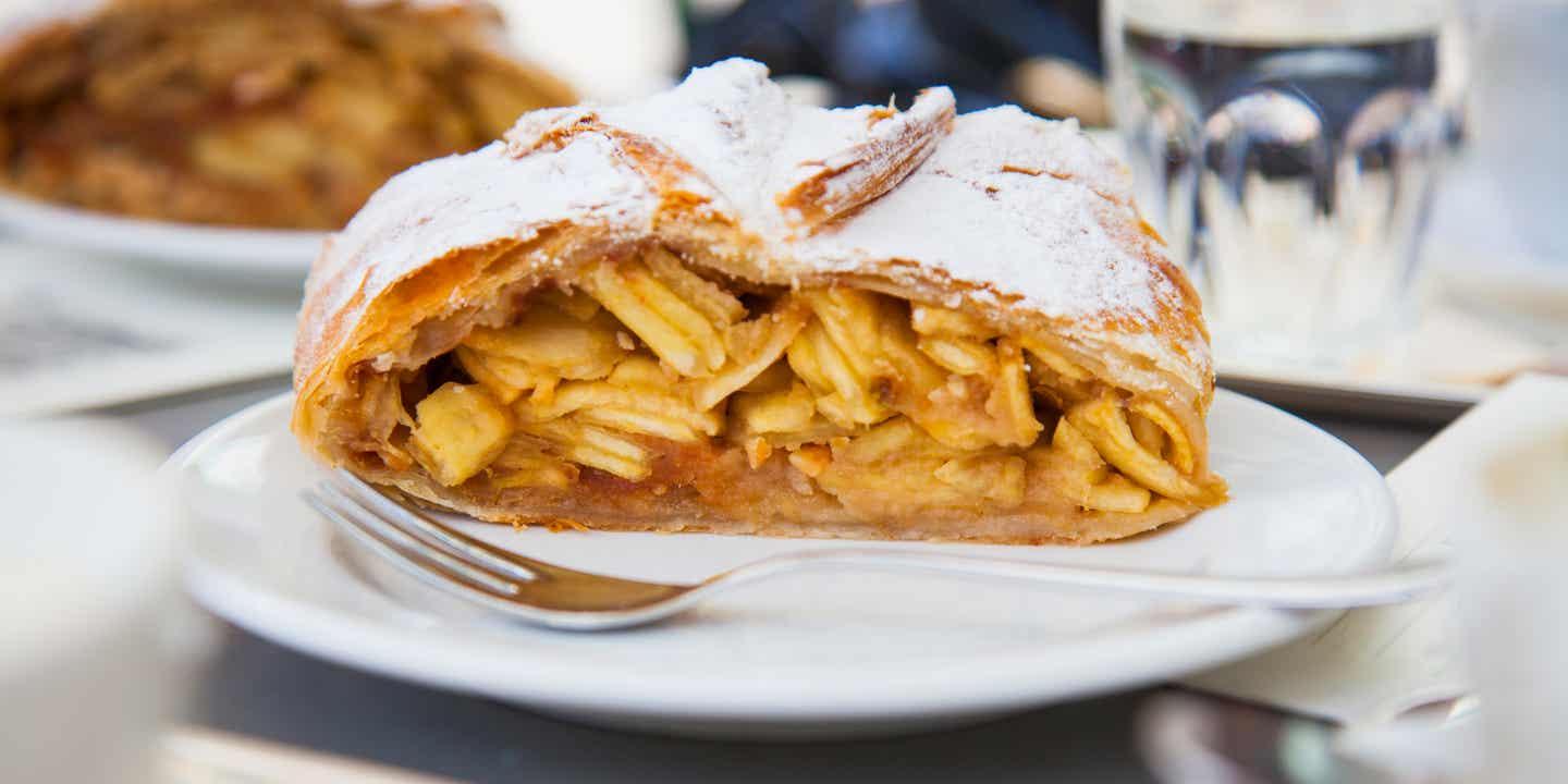 Ein Stück Apfelstrudel auf einem Teller mit Puderzucker