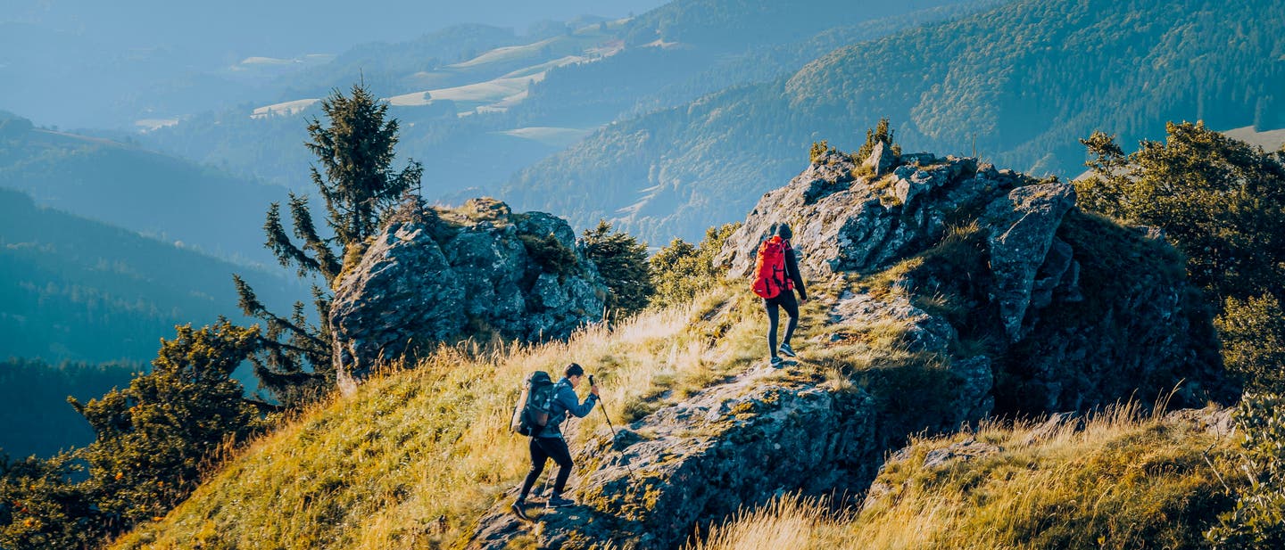 Wandern im Schwarzwald: Zwei Wanderer erklimmen einen Gipfel.