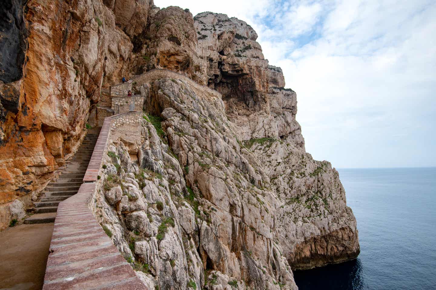 Steintreppe an der Felsenwand, die hinab zum Eingang der Neptungrotte führt