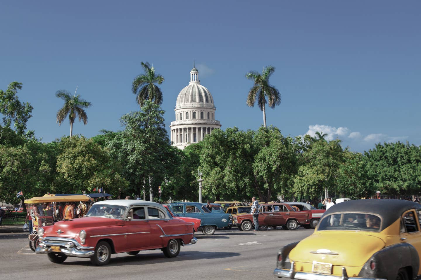 Havanna Urlaub mit DERTOUR. Altstadt Havannas mit Park und Capitol im Hintergrund. Auf der Straße Oldtimer