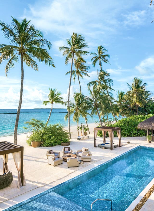 Luxusurlaub auf den Malediven Malediven Noonu Atoll Velaa Private Island Pool Sonnenliegen und Palmen am Pool