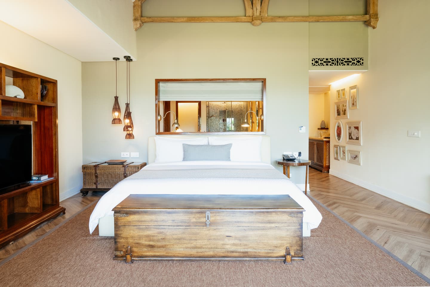 Doppelbett und halb offenes Bad in einer Heritage Beach Junior Suite des Resorts