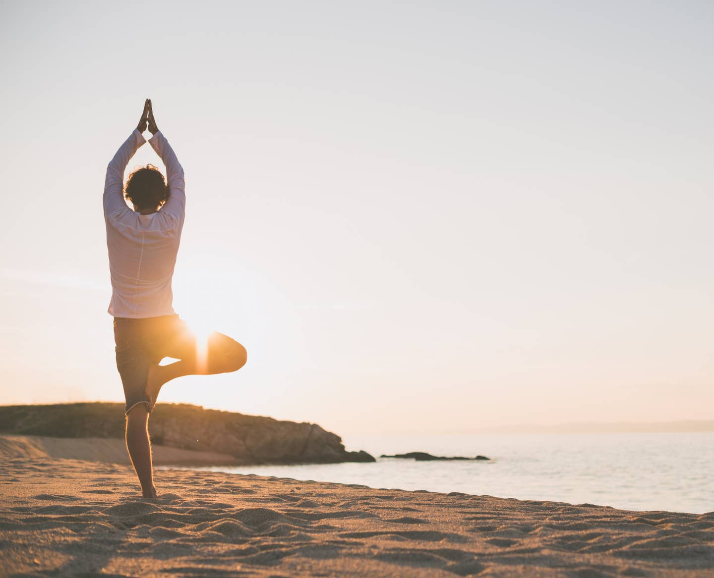 Mann macht Yoga am Strand Mann macht Yoga am Strand