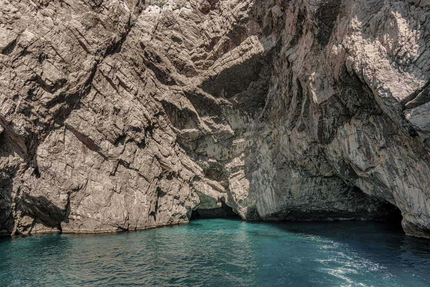 Capri Urlaub mit DERTOUR. Eingänge zu Grotten auf der Insel Capri vom Boot aus nächster Nähe aufgenommen