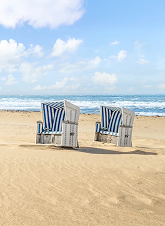 Jetzt entdecken Nordseestrand mit zwei Strandkörben und Meer im Hintergrund