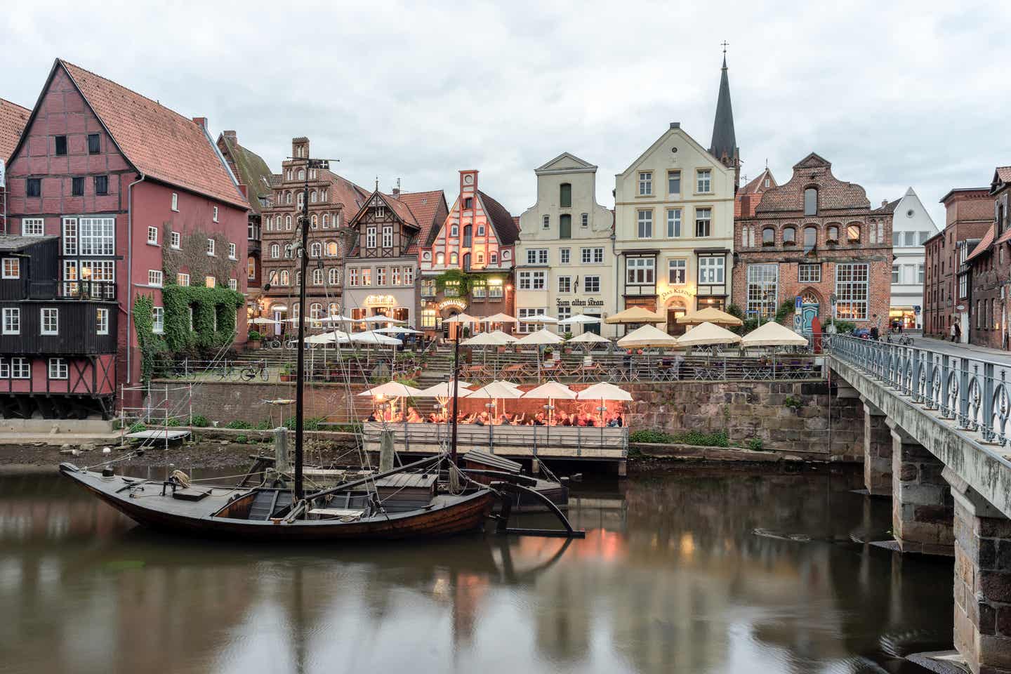 Urlaub in der Lüneburger Heide mit DERTOUR. Lüneburgs Altstadt mit historischen Häusern und Gastronomieam frühen Abend