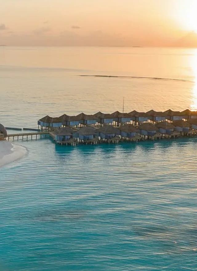 Jetzt entdecken Outrigger Maldives Maafushivaru Resort von Oben beim Sonnenuntergang